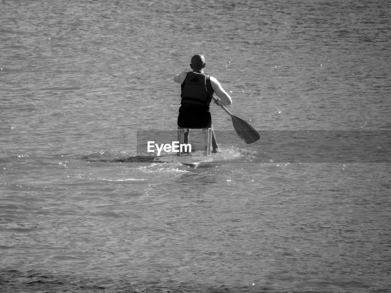 Rear view of man paddleboarding in sea