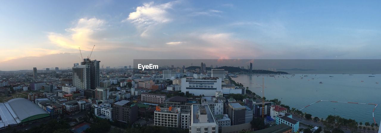 Panoramic view of cityscape by sea against sky