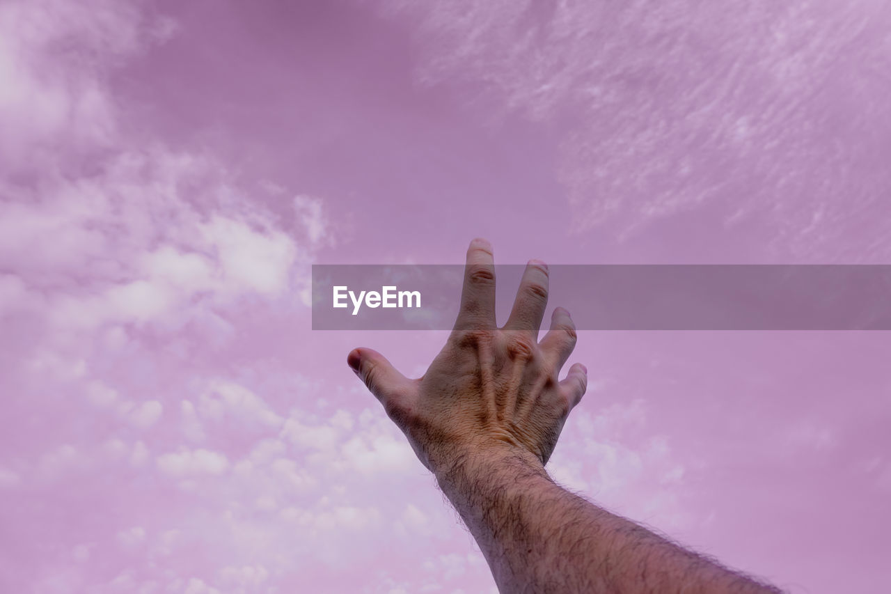 cropped hand of woman gesturing against sky
