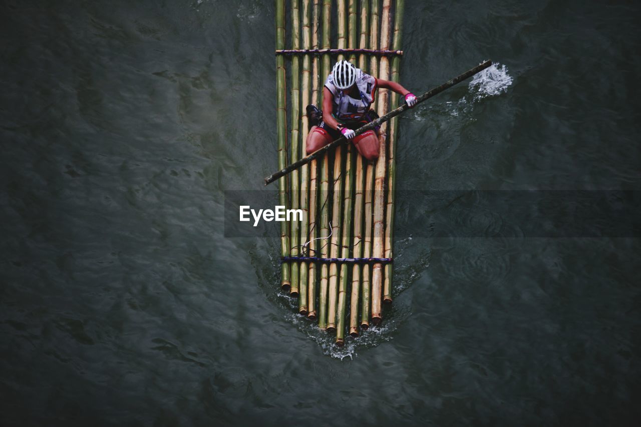 High angle view of man bamboo rafting on river