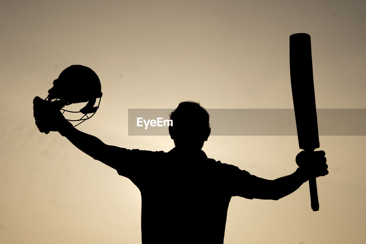 Silhouette of a cricketer celebrating after getting a century in the cricket match. indian players