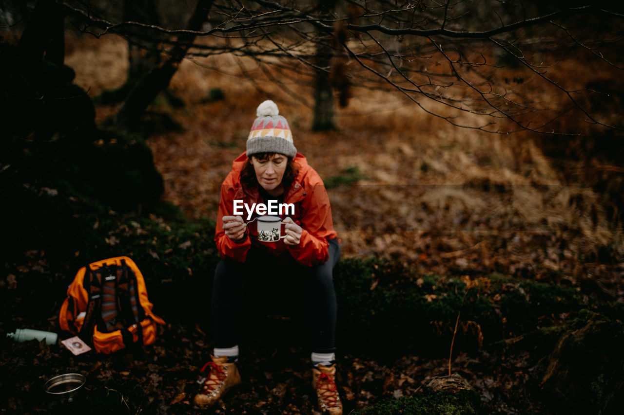 Woman drinking coffee in forest