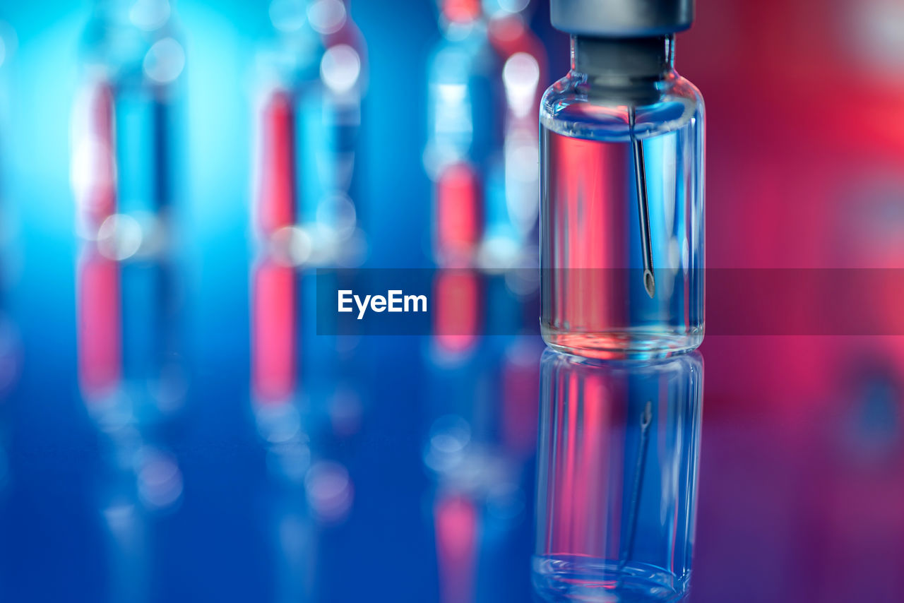 Close-up of syringe against reflective background - vaccination