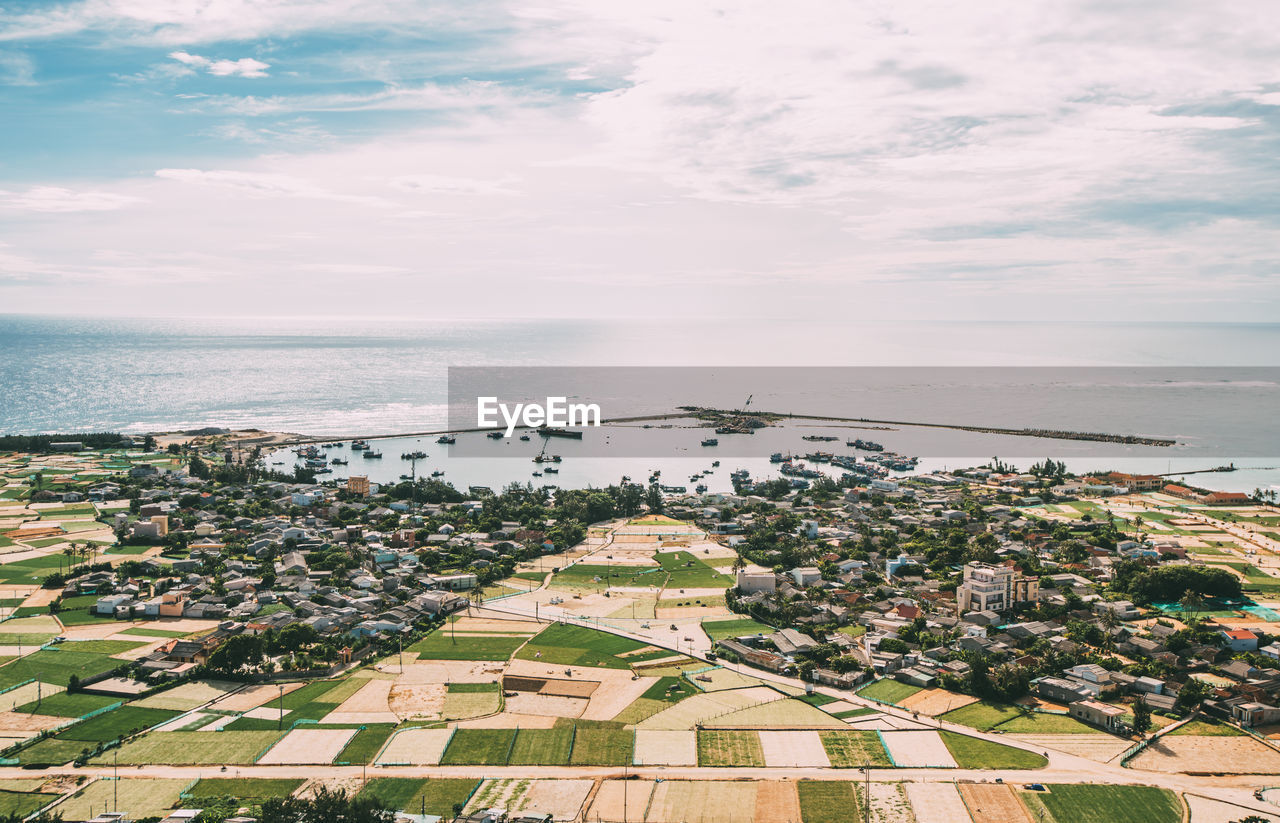High angle view of townscape by sea against sky