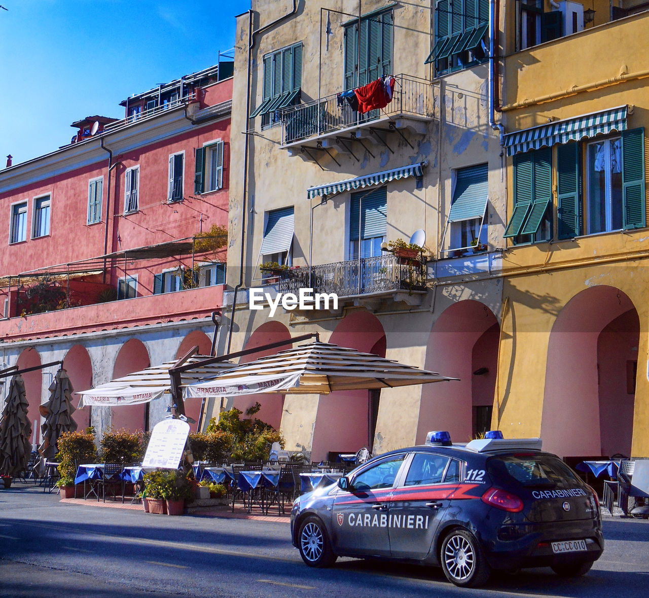 CARS ON ROAD BY BUILDINGS AGAINST SKY