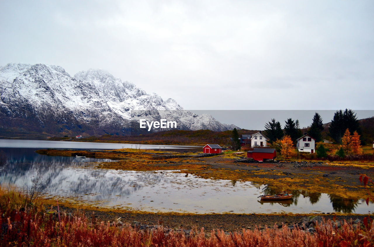 Low tide in the fjord with mountain view and houses on the bank