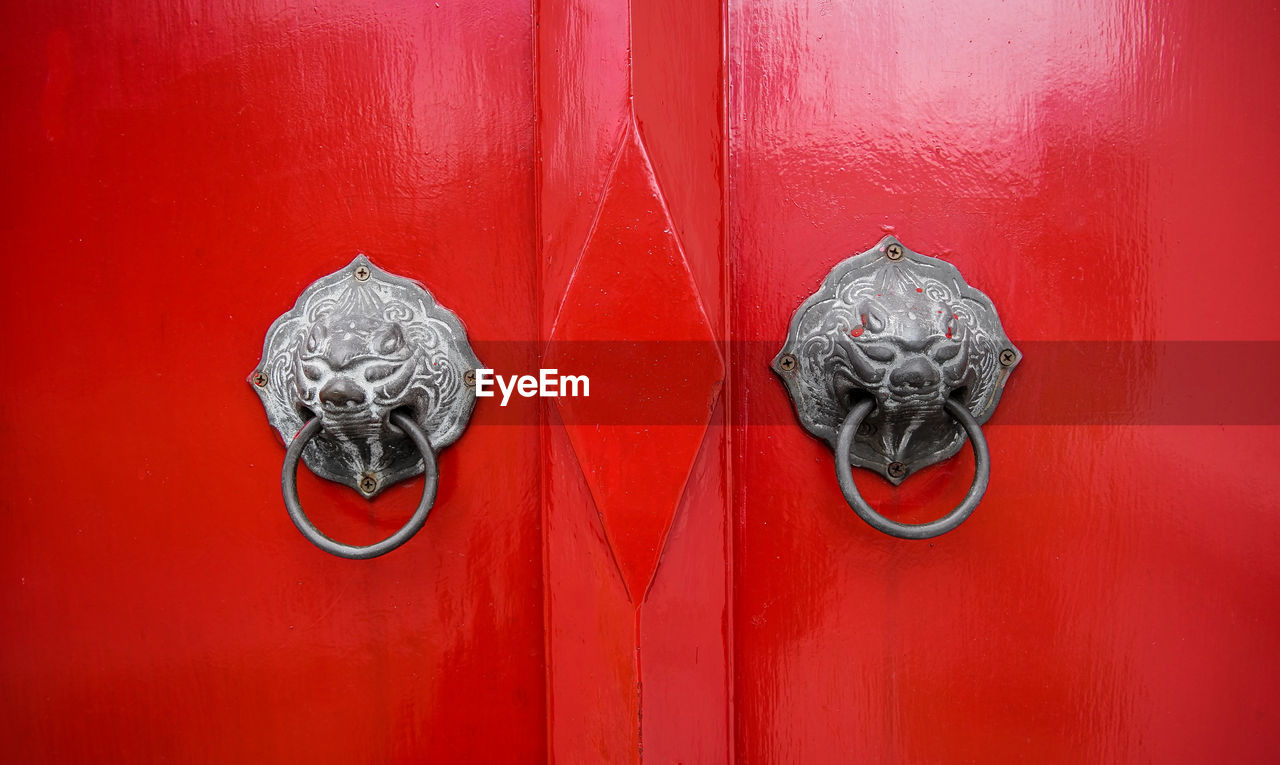 Metallic knockers on red door