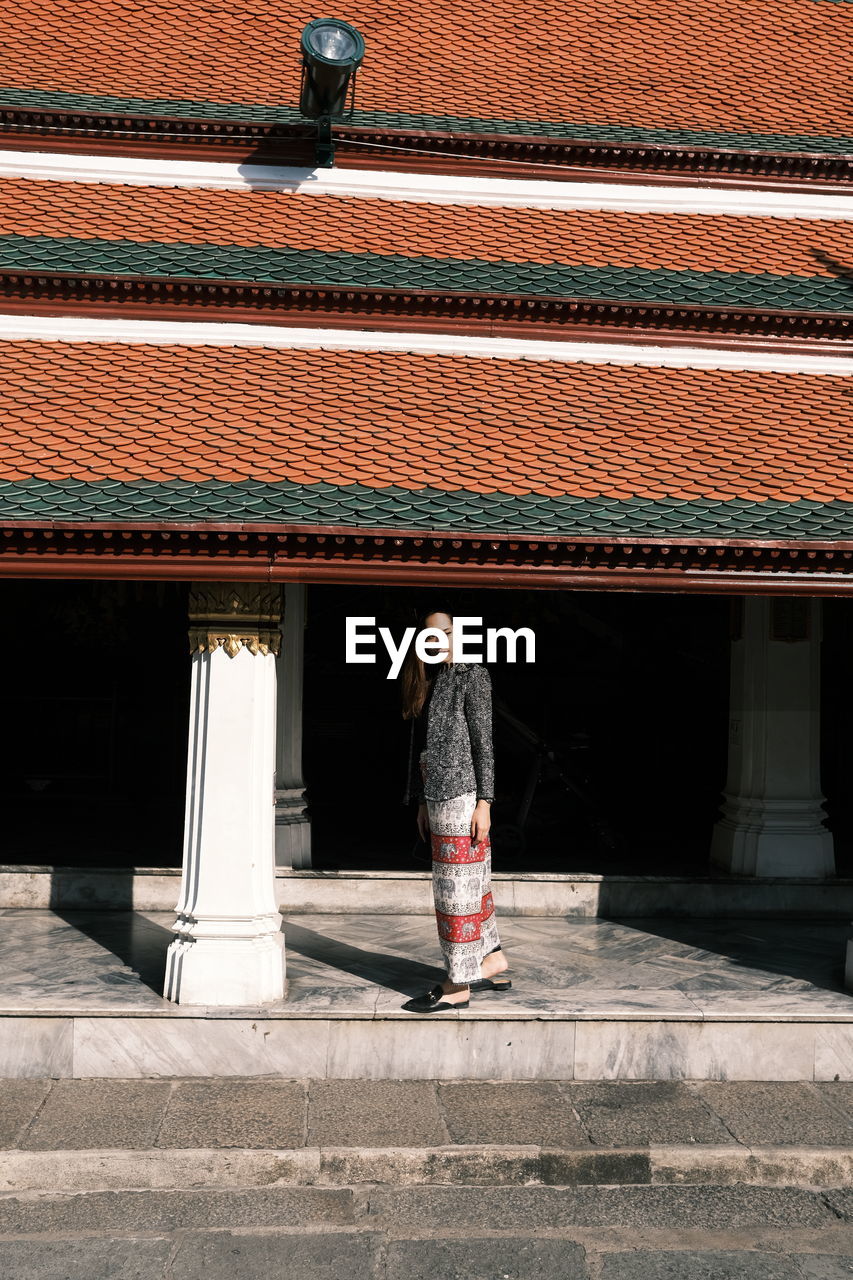 Woman standing against building