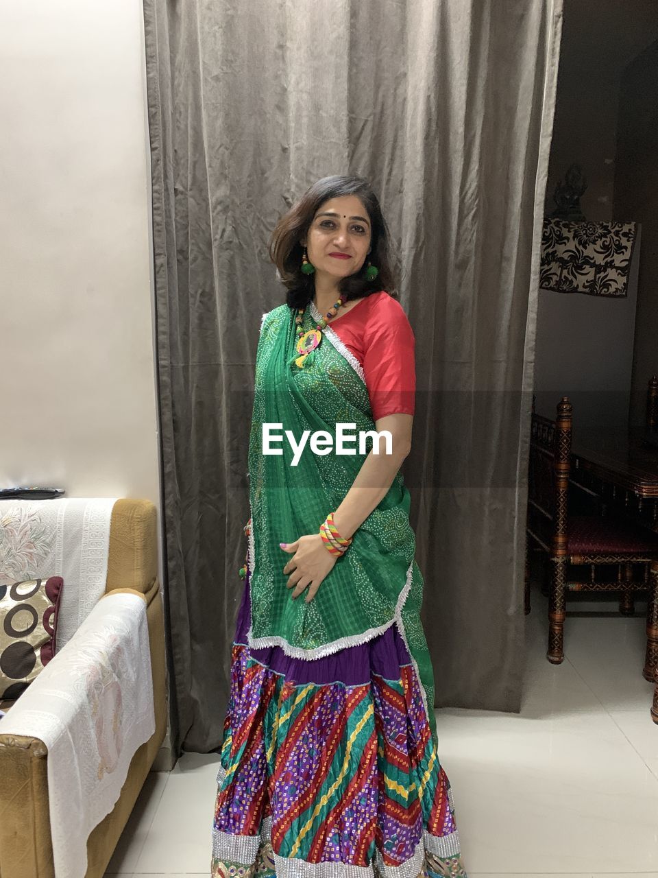 Portrait of woman wearing sari standing in living room at home