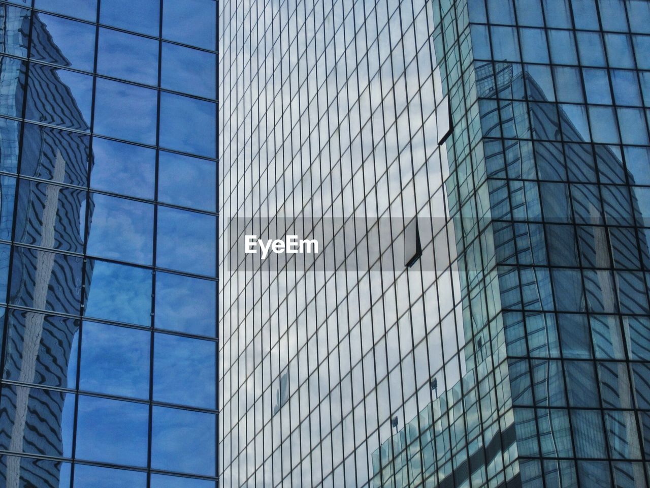 Low angle view of glass building against sky