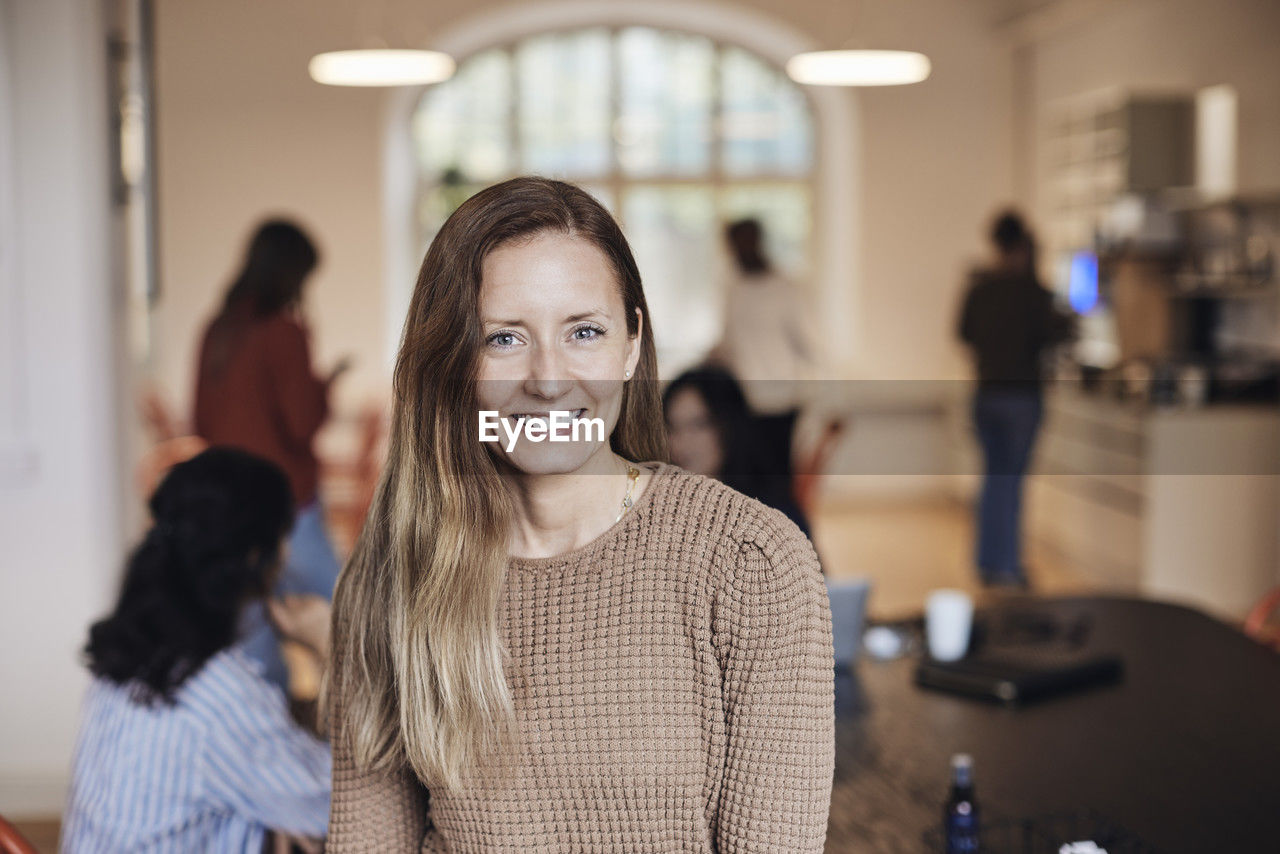 Portrait of smiling female entrepreneur at coworking office