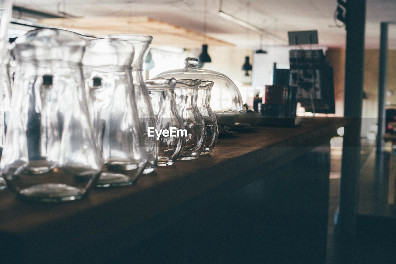 Empty glass jugs on counter at bar