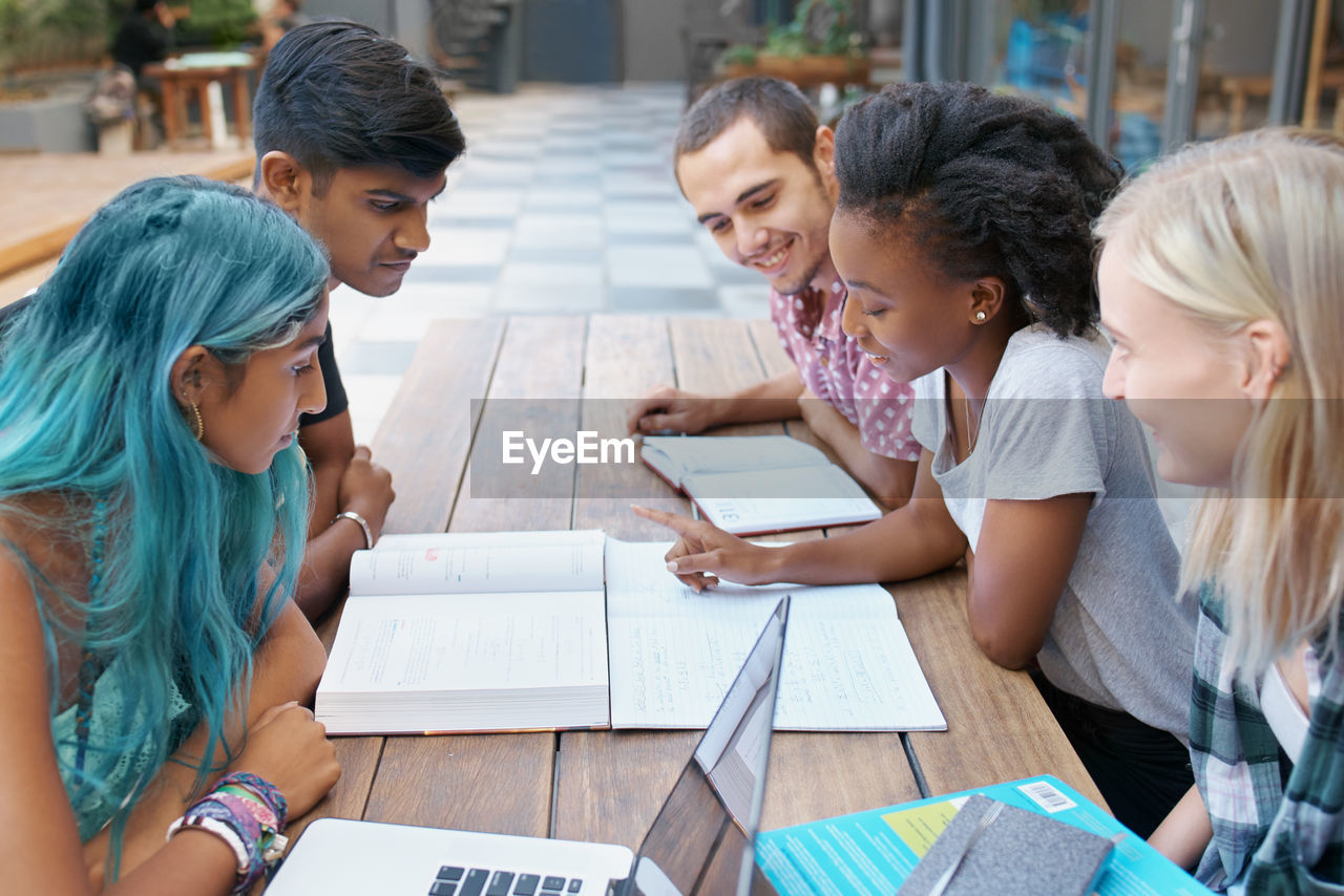 Cheerful friends studying at campus