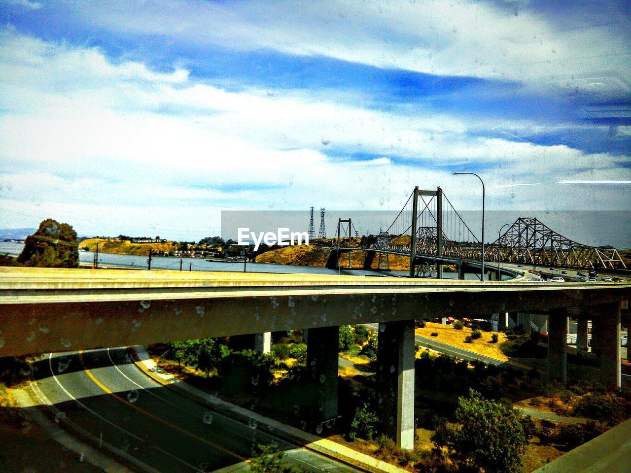 VIEW OF BRIDGE OVER RIVER AGAINST CLOUDY SKY