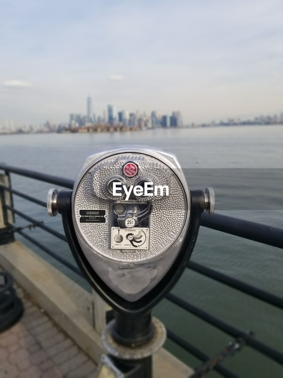 Close-up of coin-operated binoculars with cityscape in background