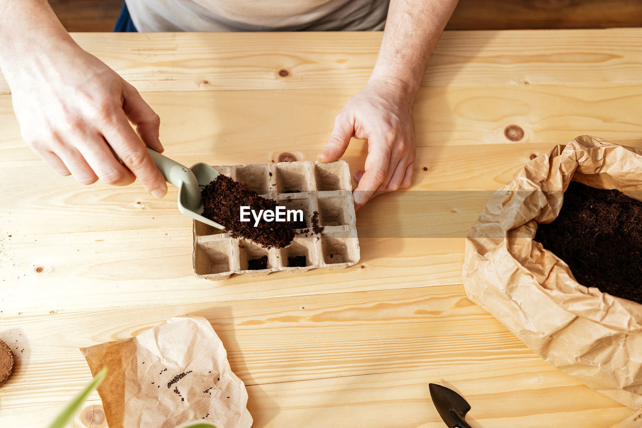 cropped hands of man preparing food on table