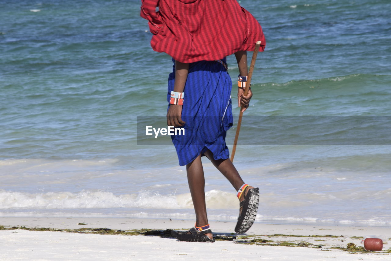 Rear view of man walking at beach