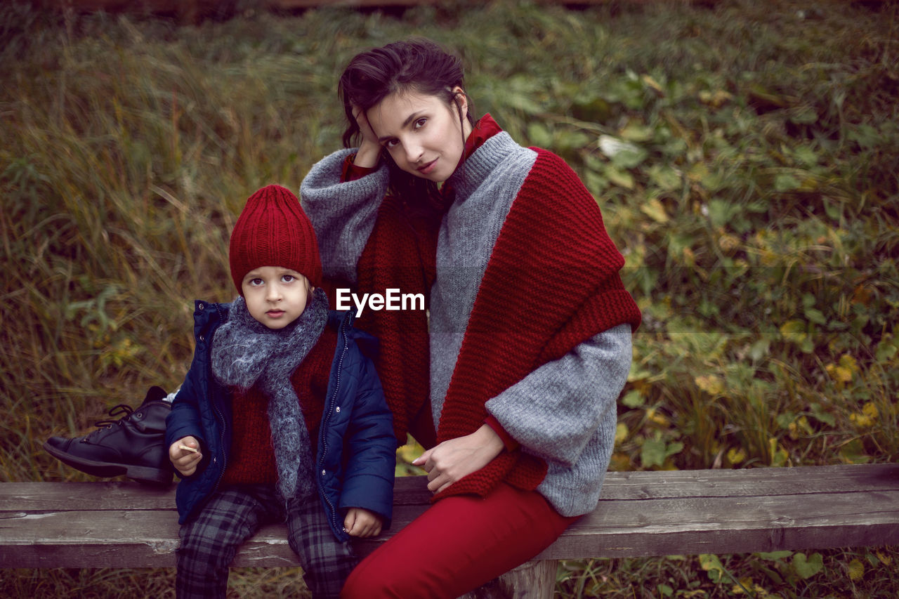 Mom and son sitting on a street bench in the fall