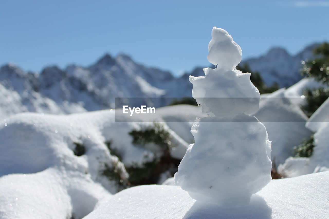 Close-up of snow covered mountain against clear sky