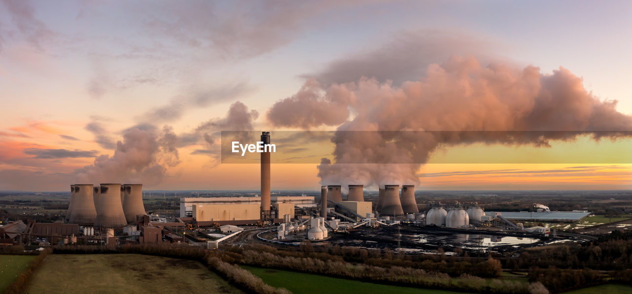 Aerial landscape of coal fired power station at sunset with coal stack and biofuel storage tanks