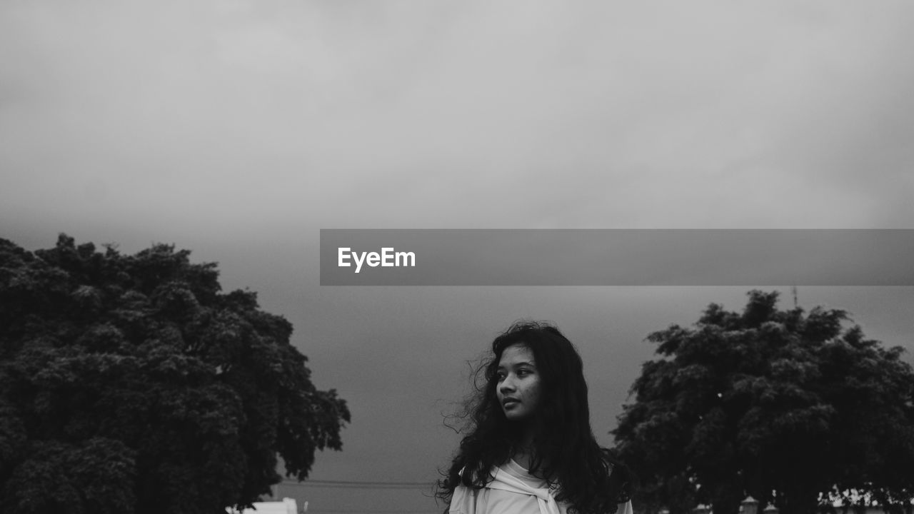 Low angle view of woman standing against sky