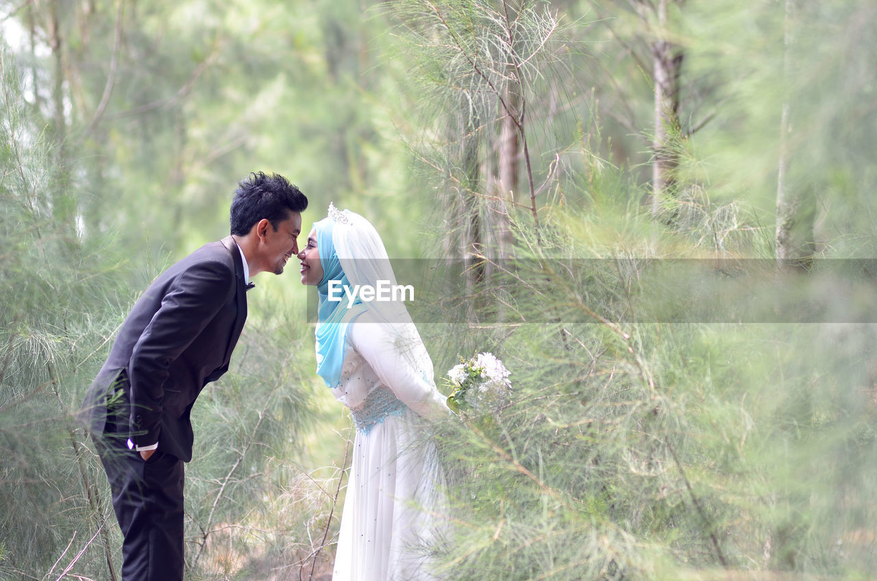 Side view of couple standing on land