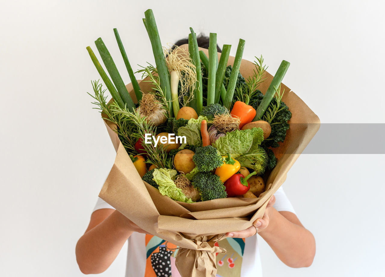 MIDSECTION OF PERSON HOLDING VEGETABLES