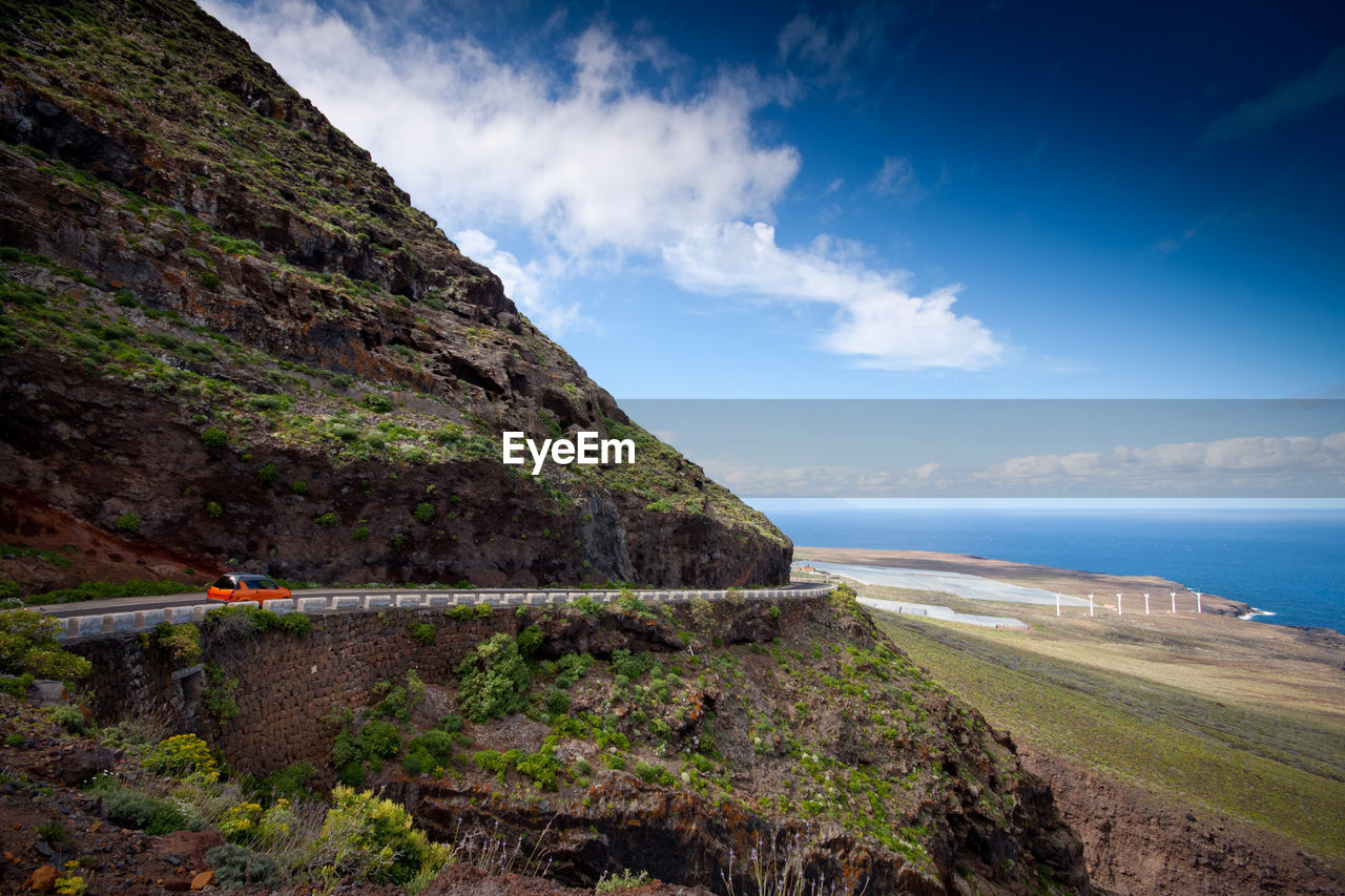 Scenic view of mountain by sea against sky