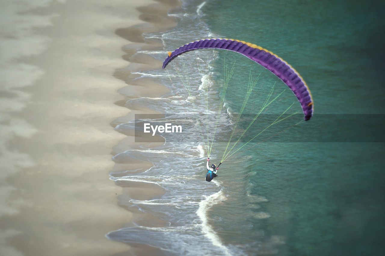 High angle view of person paragliding over water
