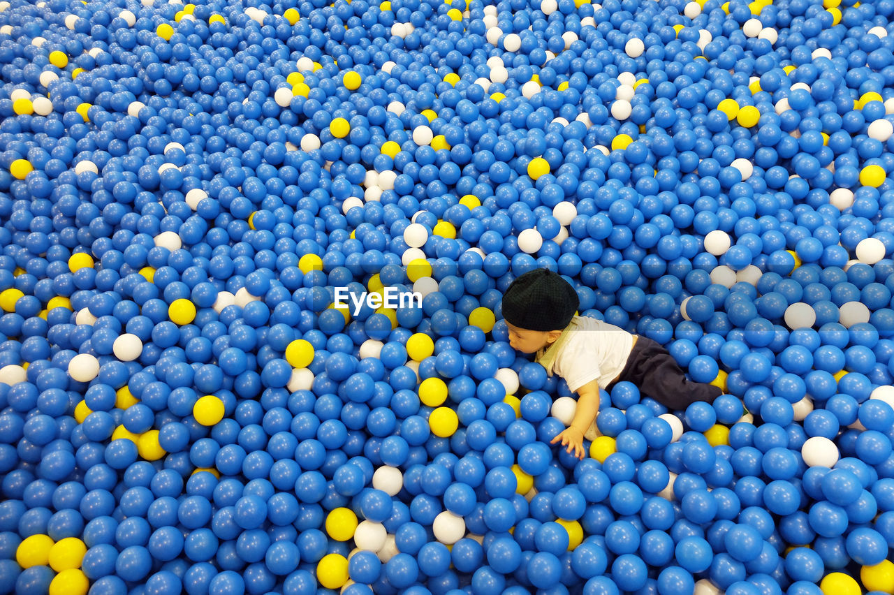 High angle view of boy playing in ball pool