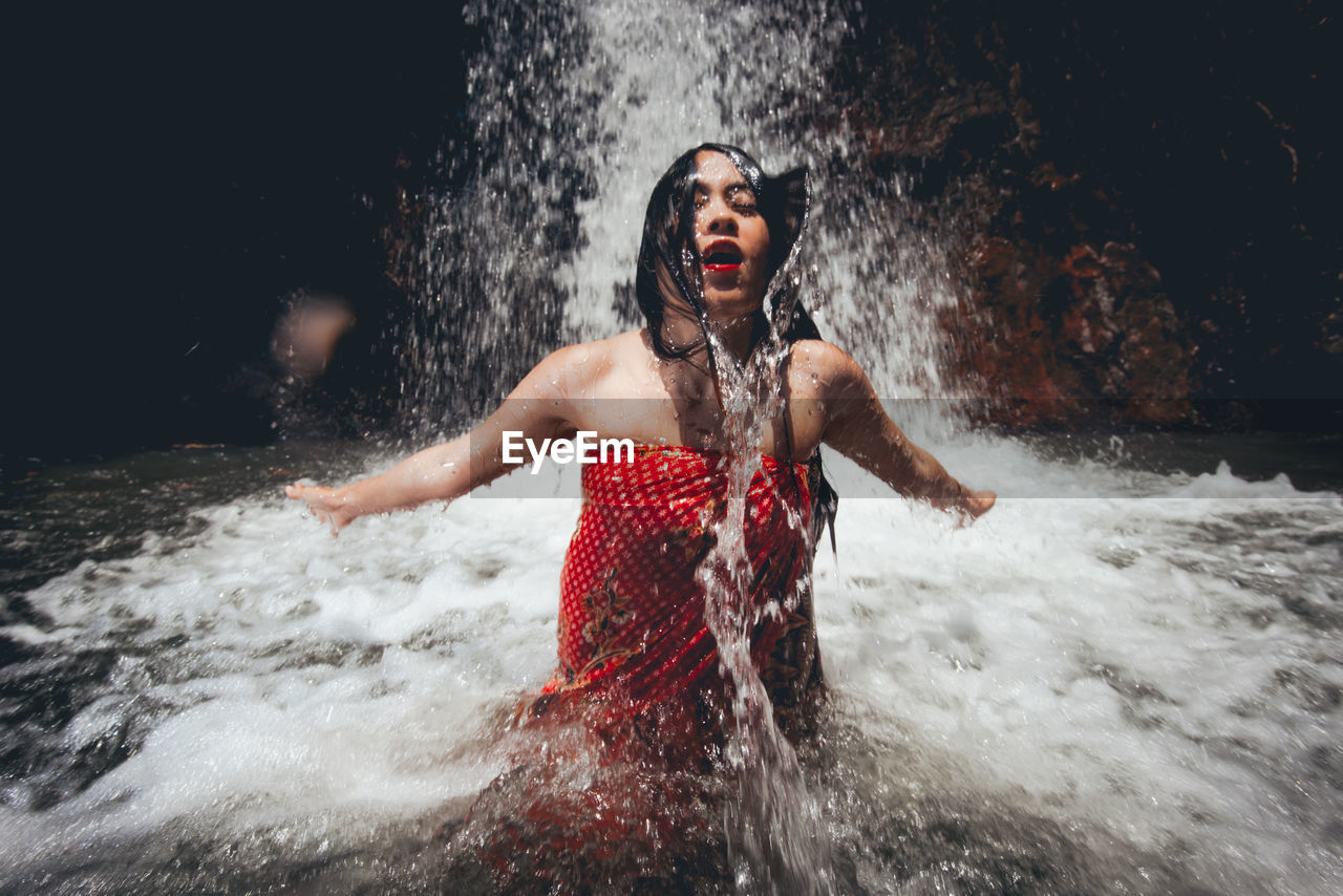 Young woman enjoying waterfall