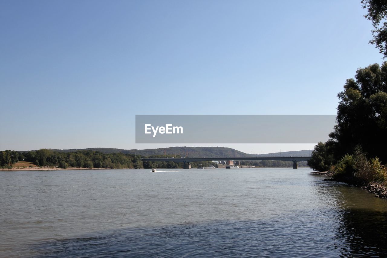 SCENIC VIEW OF RIVER BY MOUNTAINS AGAINST CLEAR SKY