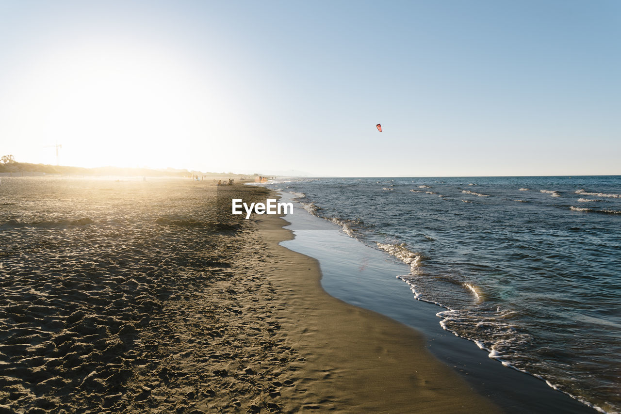 Beautiful summer afternoon on the beach with the sun on the horizon in mediterranean sea, oliva