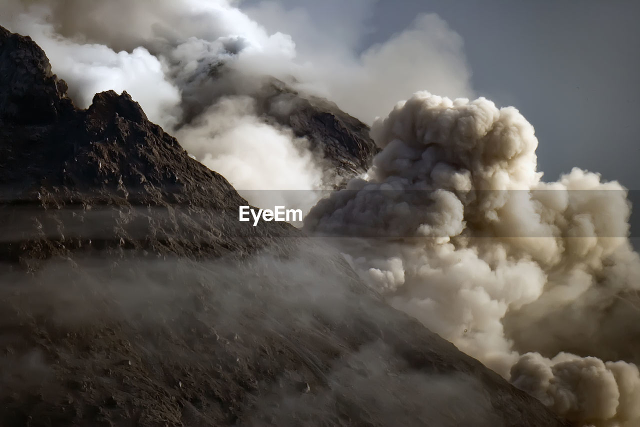 Volcano erupting against sky