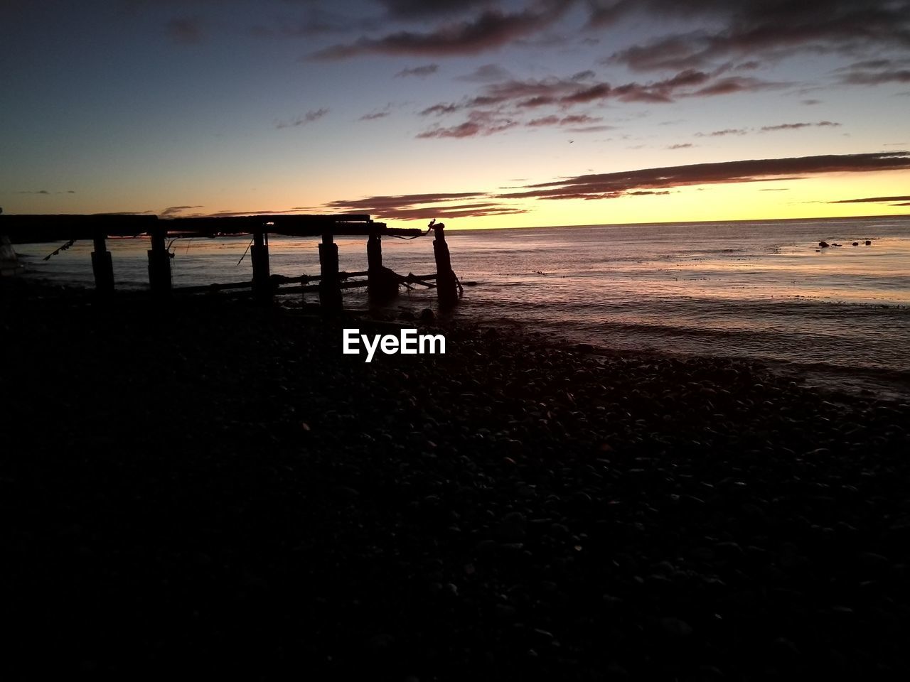 SILHOUETTE BEACH AGAINST SKY DURING SUNSET