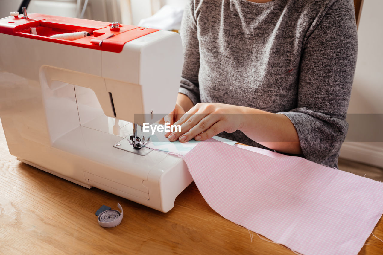 Midsection of woman working on table at home