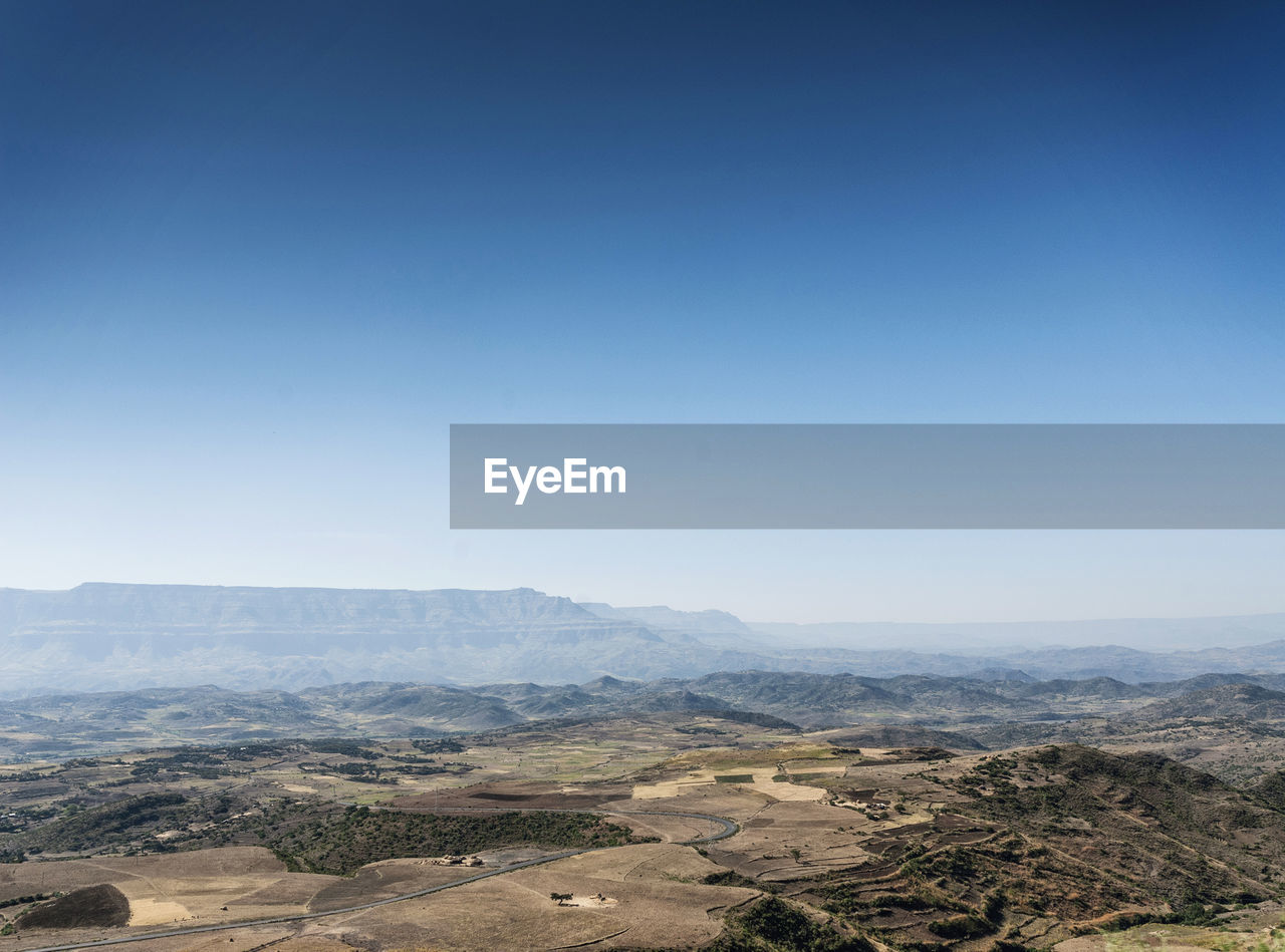 Scenic view of dramatic landscape against clear blue sky