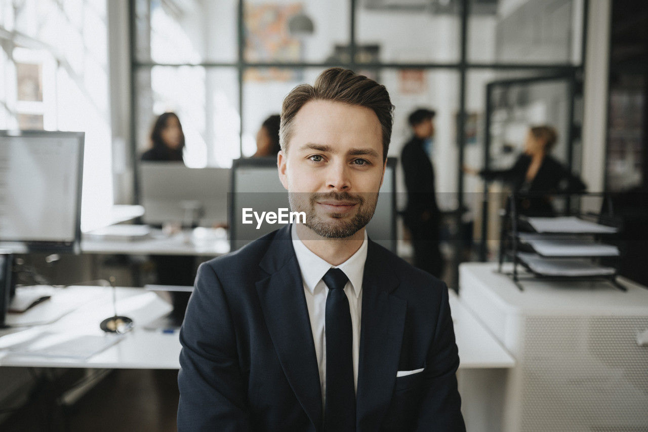 Portrait of male entrepreneur wearing black blazer at office