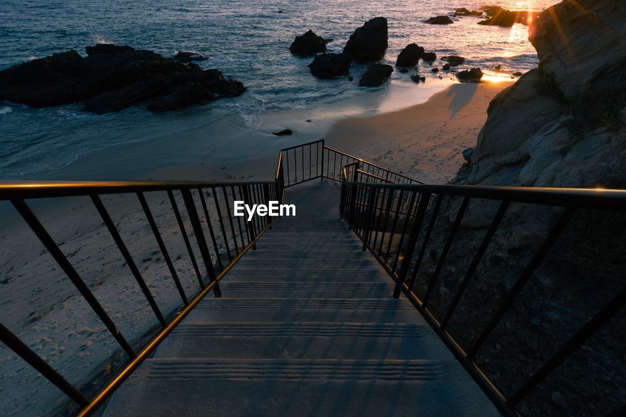 High angle view of staircase leading towards beach during sunset