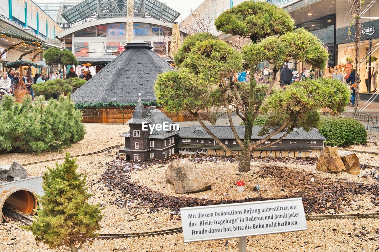 INFORMATION SIGN BY TREES AND BUILDINGS