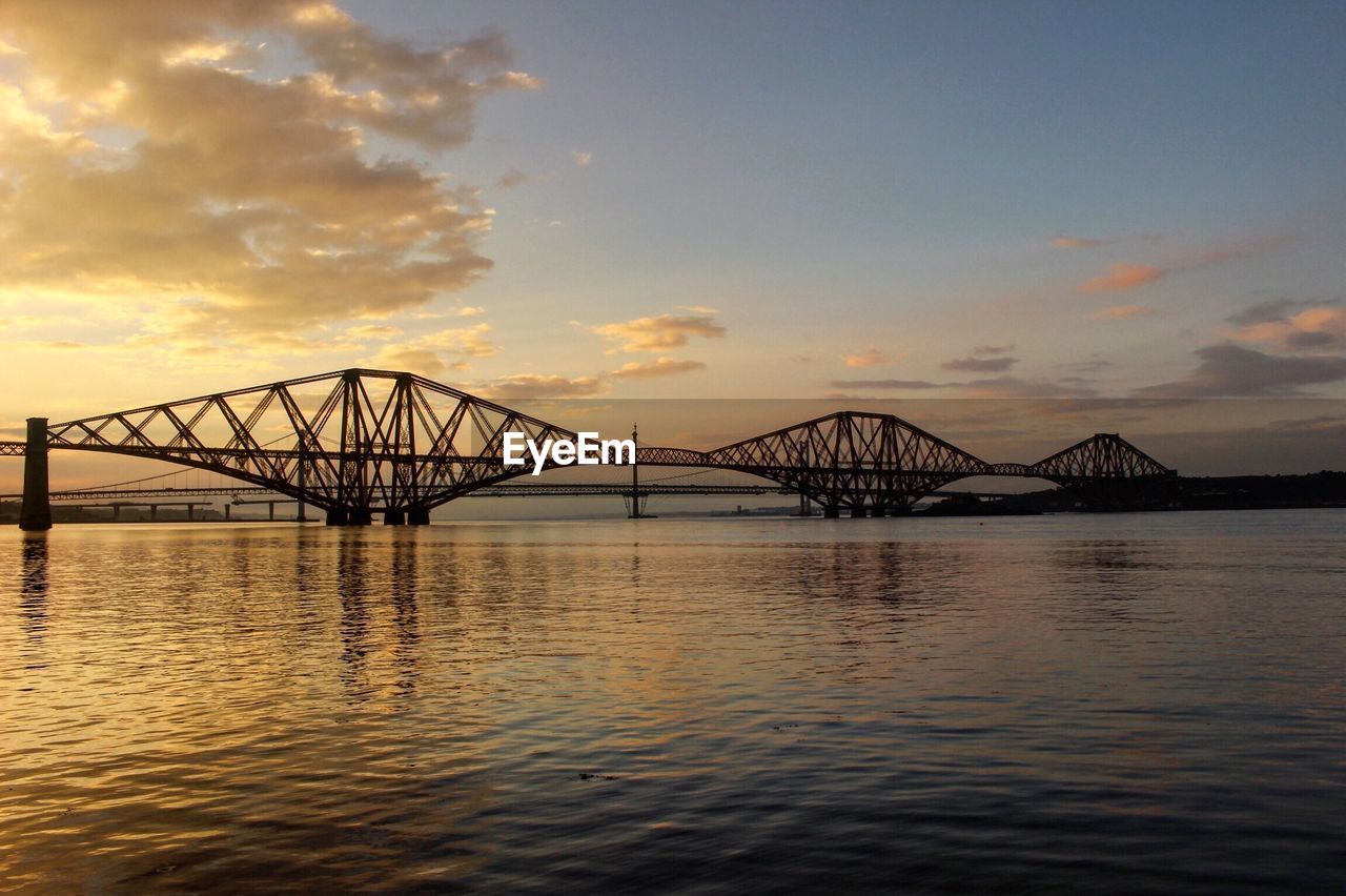 Forth bridge over sea against sky during sunset