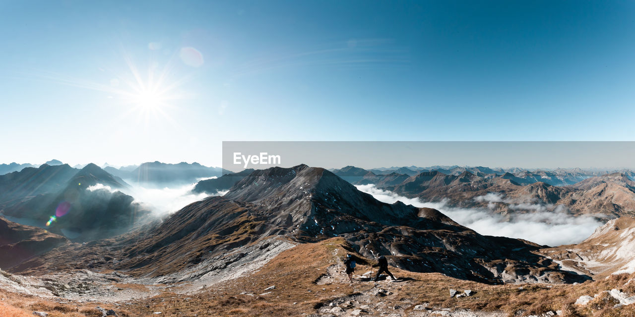 SCENIC VIEW OF SNOWCAPPED MOUNTAINS AGAINST BRIGHT SUN