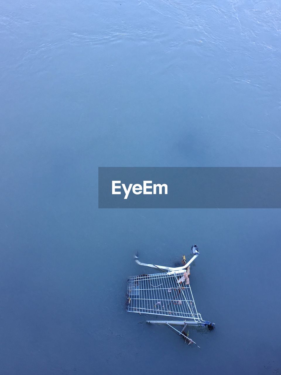 High angle view of abandoned shopping cart in sea