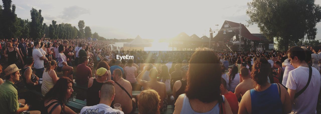 People at music festival on beach during sunny day