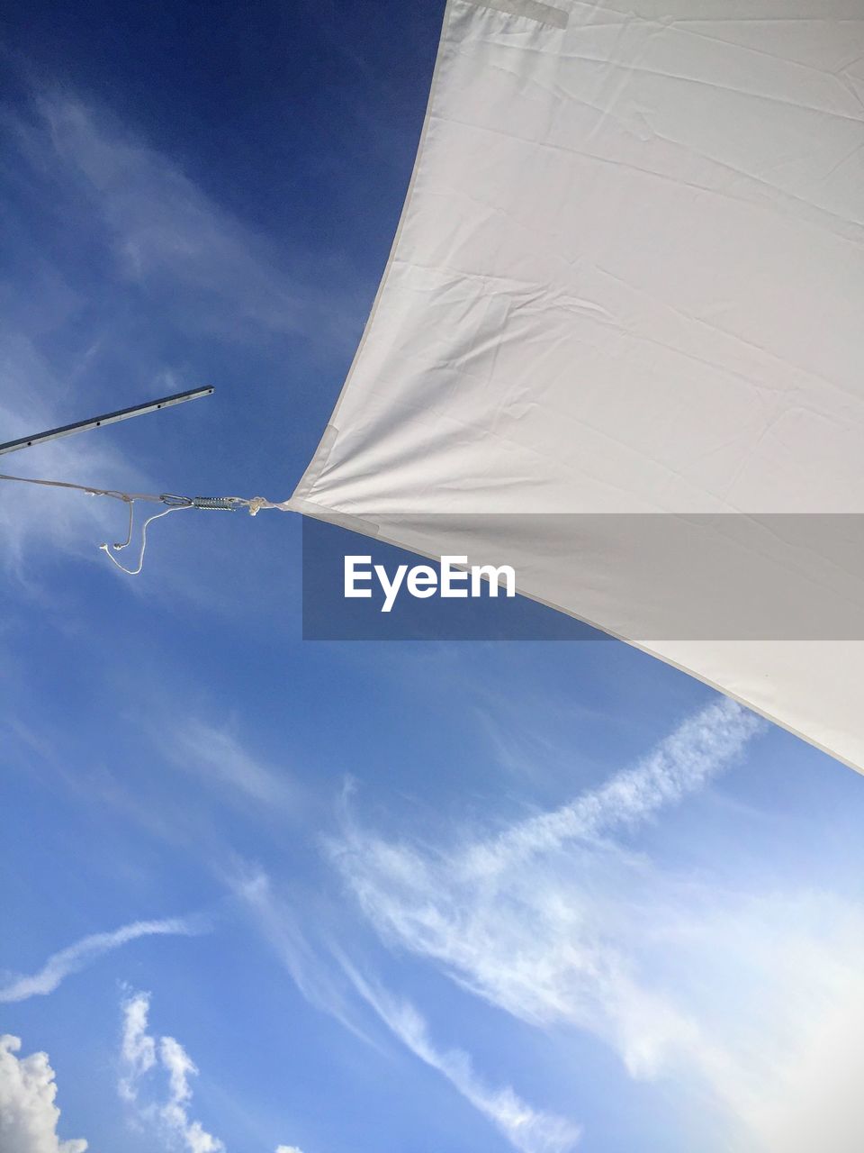 Low angle view of vapor trail, clouds, sky and white sail