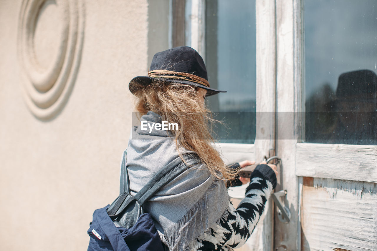 Rear view of woman locking house door