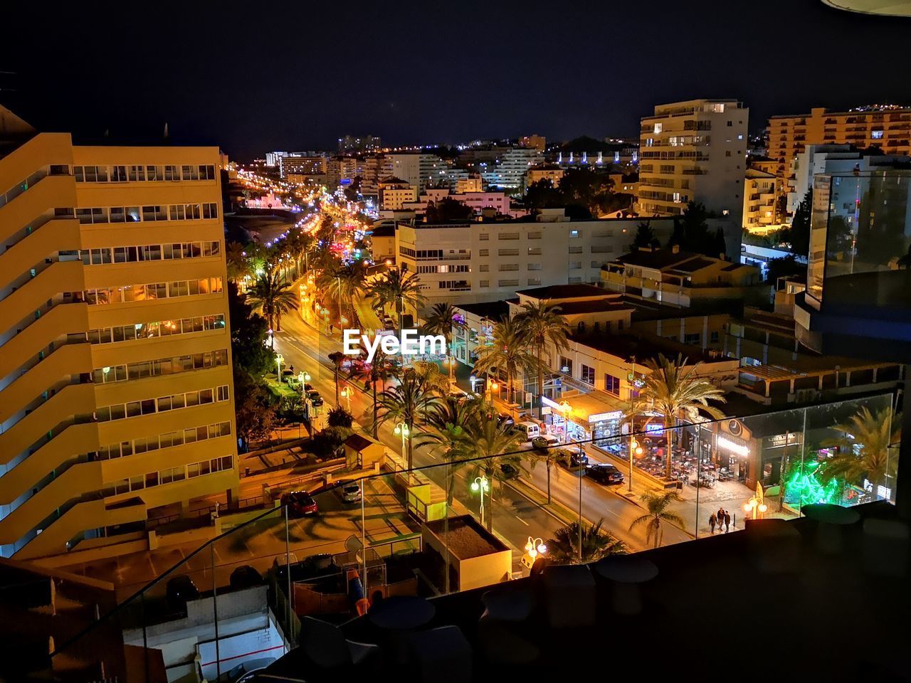 HIGH ANGLE VIEW OF ILLUMINATED CITY BUILDINGS AT NIGHT