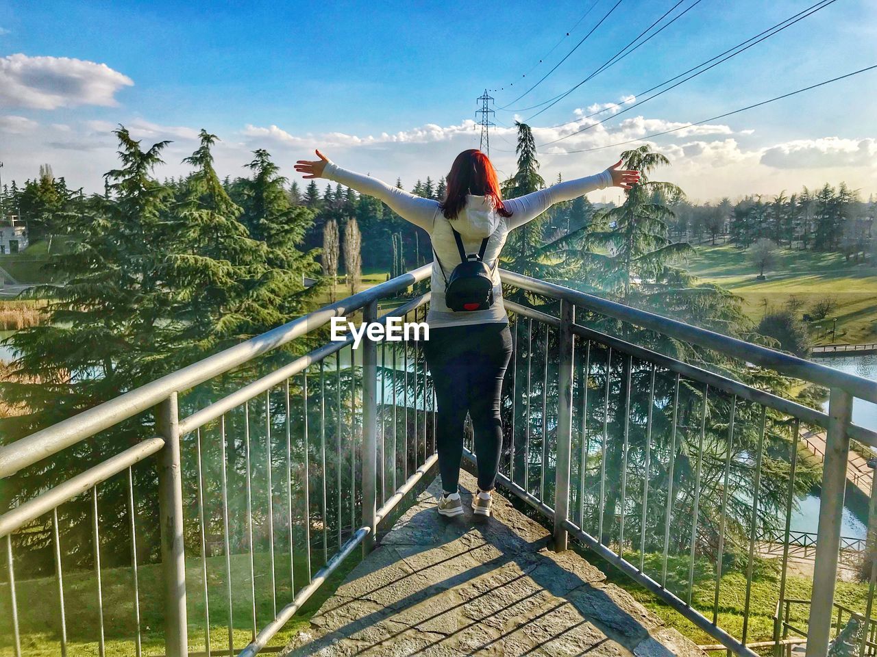 Rear view of woman standing on footbridge