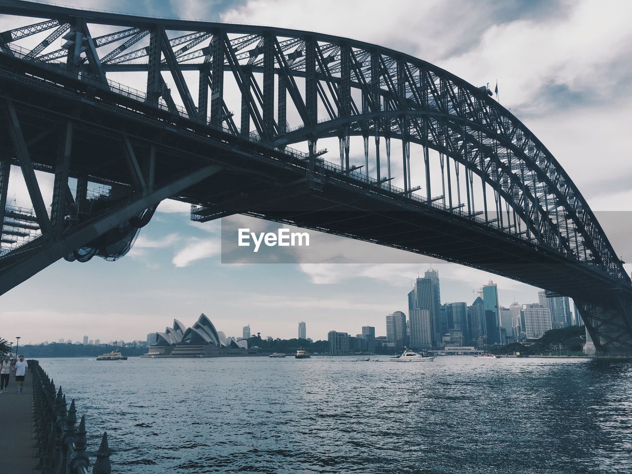 Sydney harbor bridge over thames river against sky