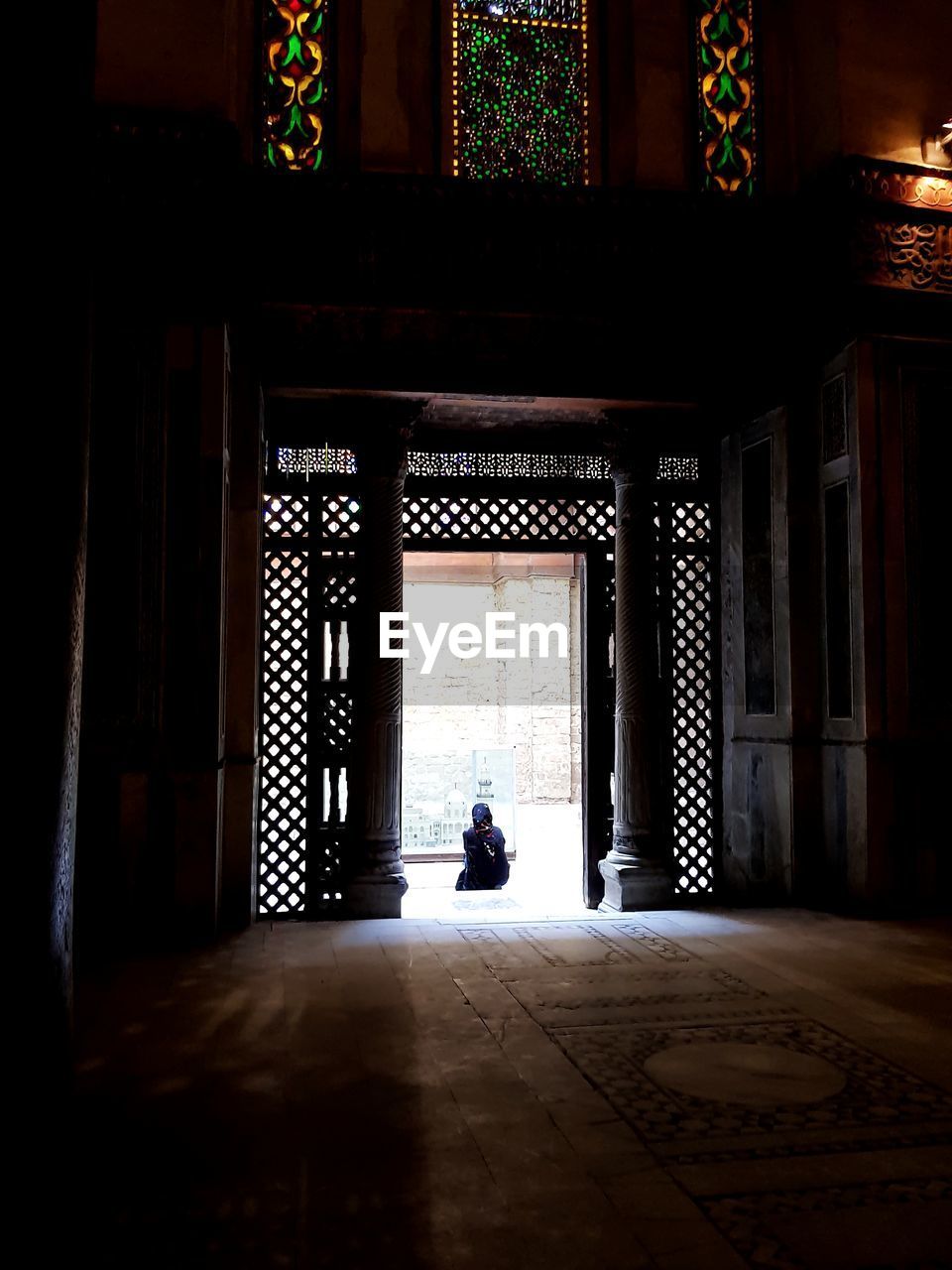 WOMAN SITTING ON DOORWAY OF BUILDING